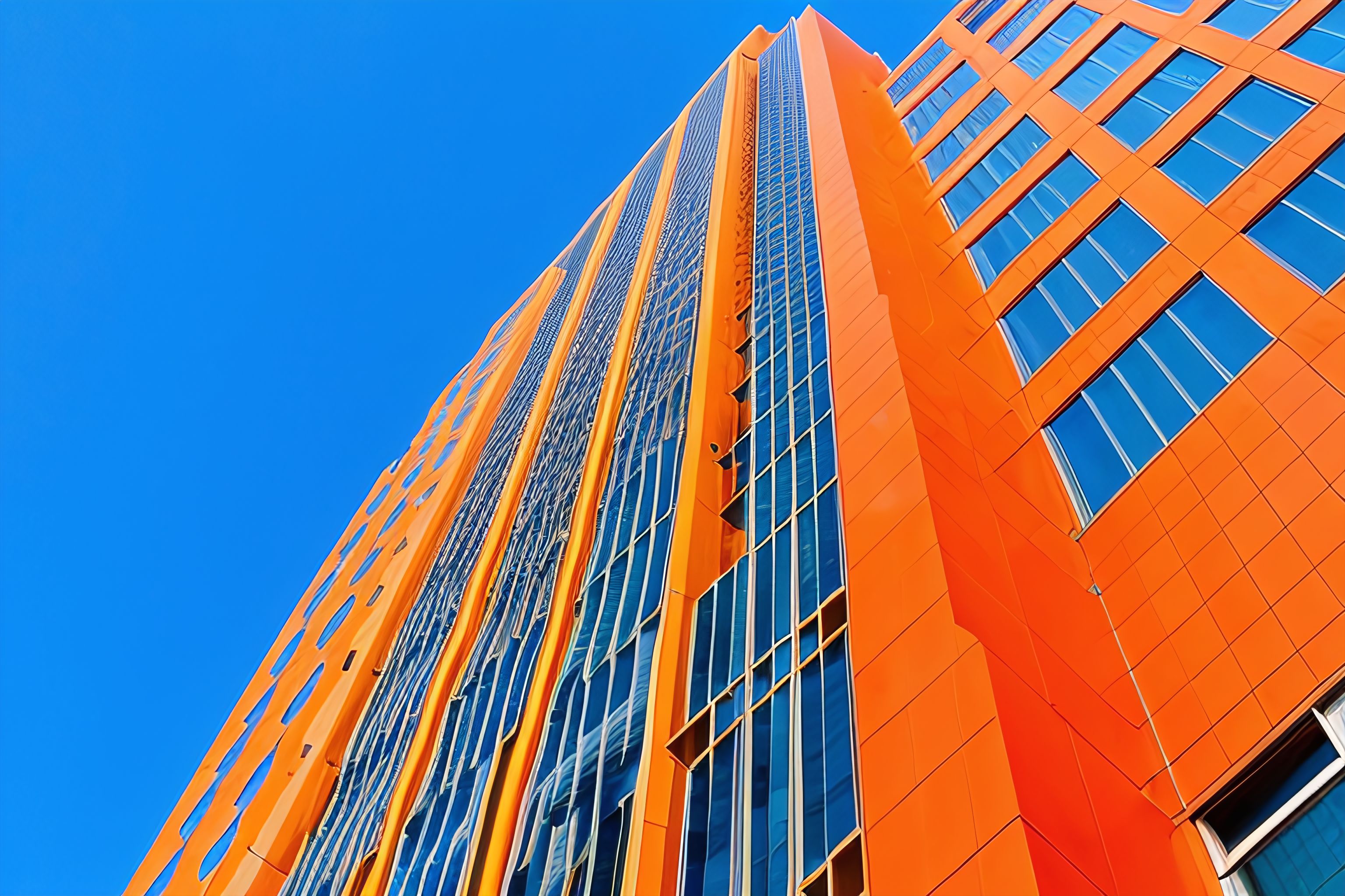 An orange skyscraper against a blue sky.