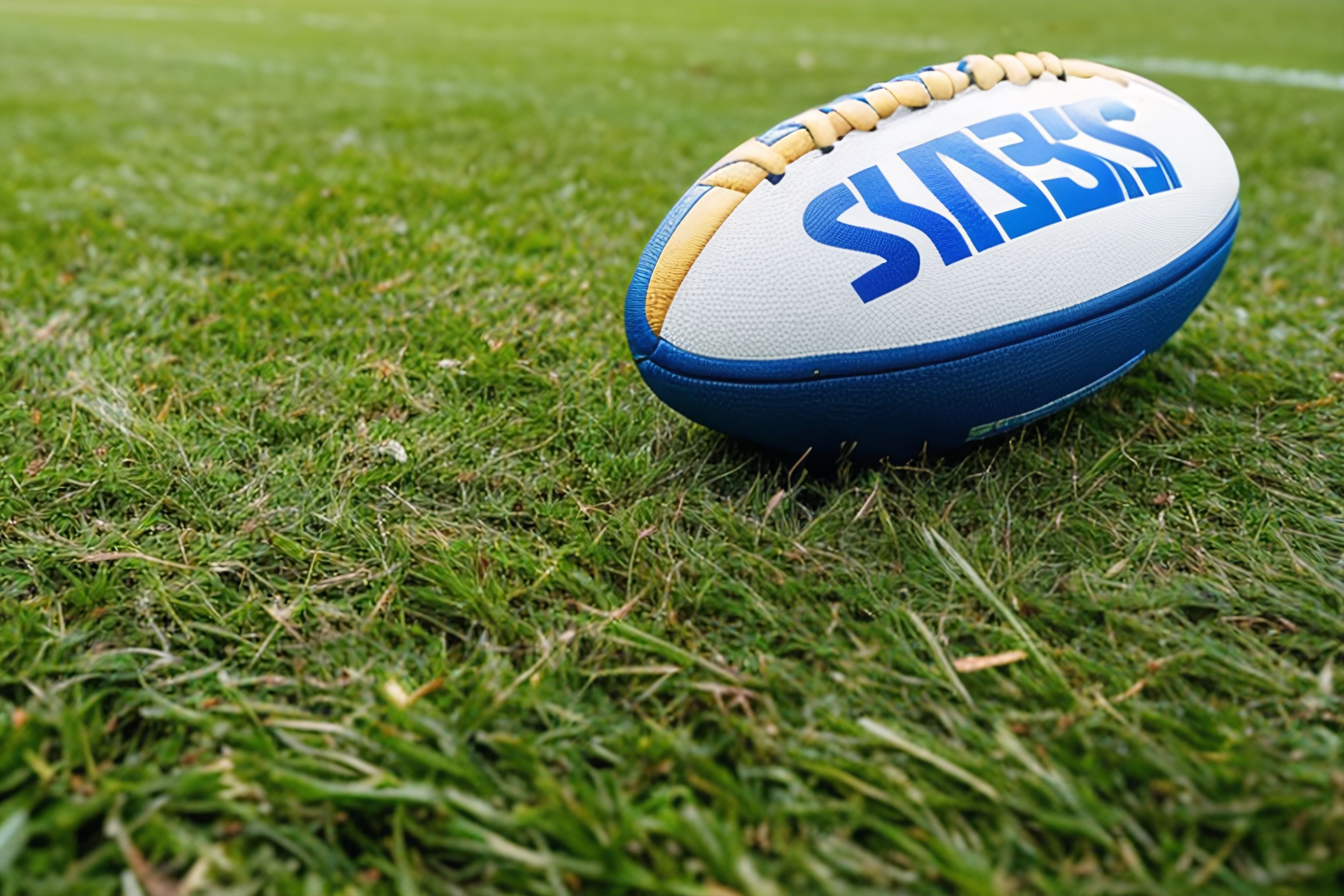 A rugby ball and cleats on a grass field