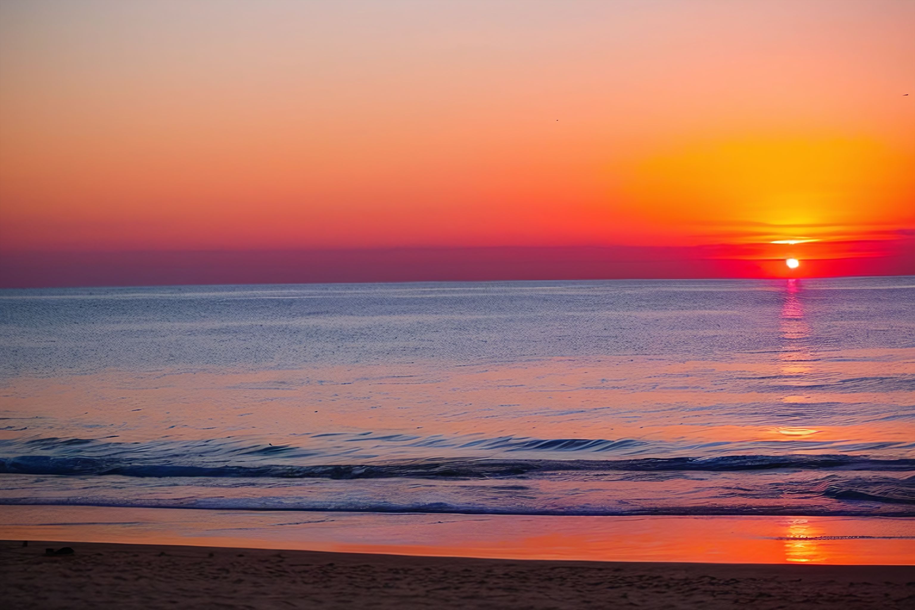 A serene ocean sunset with vibrant orange and pink hues.